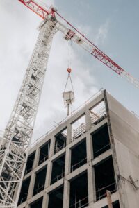 Crane assisting with Houston tilt wall construction partially built building