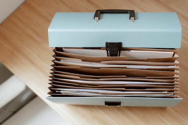 File folder open to show paperwork for closeout package being collected by Houston commercial general contractor